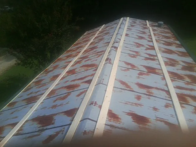 Rusted metal roof panels with new wood purlins before replacement — Storm Damage Roof Repair in Stephenson by Roofing Brothers
